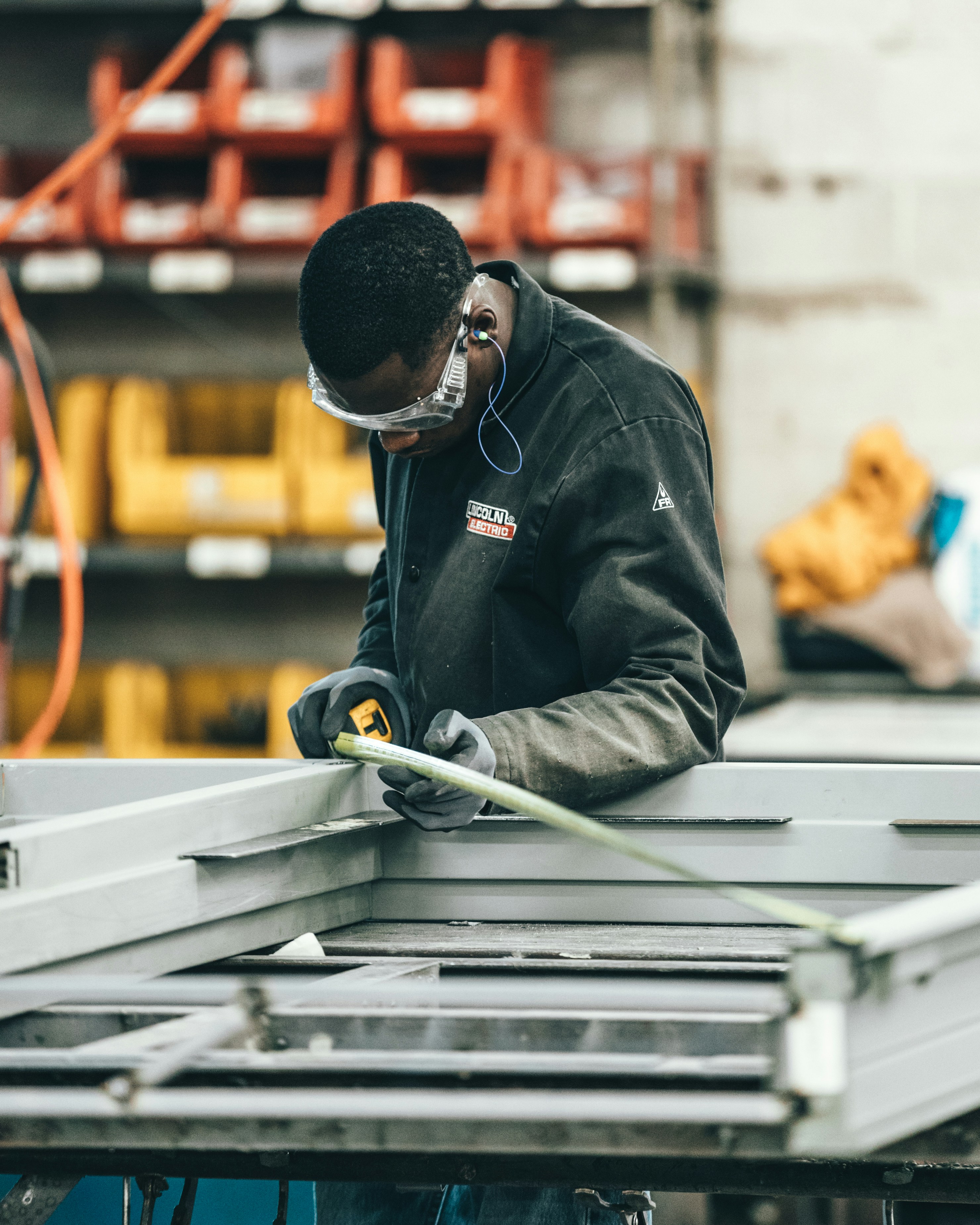 Manufacturing worker measuring a metal frame